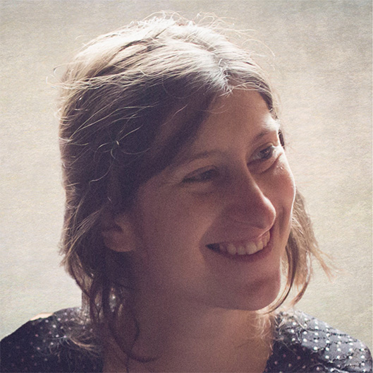 Au format carré, Jeanne Sélène. Mon portrait photo. Je suis une femme blanche avec des cheveux châtains mi-longs ici attachés. Cette photo a été prise en 2018 après la naissance de ma fille.